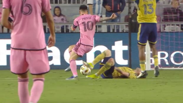 Lionel Messi dribbles over the crumpled body of an injured defender
